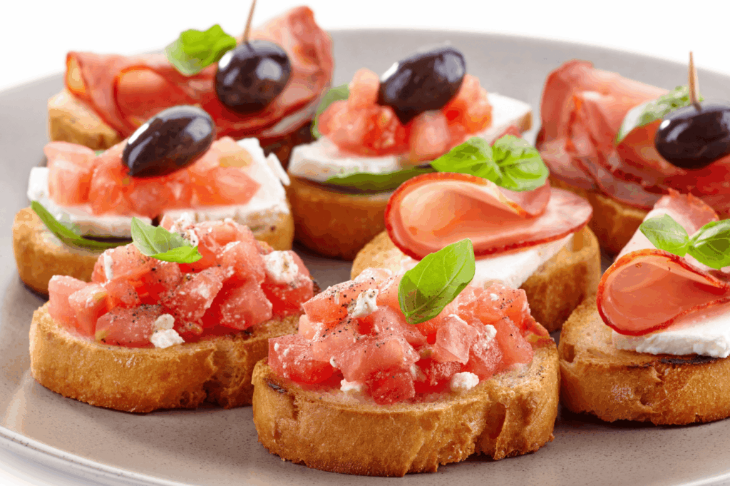 Colorful tapas platter celebrating Spanish cuisine and Spanish food, showcasing traditional Spanish dishes like a rustic Spanish dish of crusty bread and fresh bread topped with olive oil, diced tomatoes evoking tomato sauce, creamy dairy products, cured ham, chorizo, green peppers, and garlic, inspired by traditional Spanish recipes and traditional dishes. This popular tapa reflects Spanish cooking and Spanish classics alongside famous Spanish dish icons such as seafood paella, paella, Spanish omelette, patatas bravas, pimientos de padrón, mojo picón, rabo de toro, braised oxtail, black pudding, blood sausage, pork fat specialties, ground beef stews, chicken meat roasts, potatoes, rice dishes, and white rice national dish favorites. Evoking the rich flavor of the Iberian Peninsula, it draws from Basque Country, La Rioja, Canary Islands, and Canarian cuisine, perfect for a dinner party with loved ones or to eat and taste at a restaurant in Spain. While not the most famous Spanish dish or ultimate Spanish comfort food like cold soup gazpacho, deep fried croquettes with bechamel sauce, or popular desserts such as chocolate dessert, it remains a dish that embodies cuisine heritage, other ingredients artistry, and meal traditions that make visit Spain a must for any huge fan of traditional Spanish food, whether dining at El Celler de Can Roca or another El Celler gem, enjoying seafood, dessert, or savory bites served hot and delicious.
