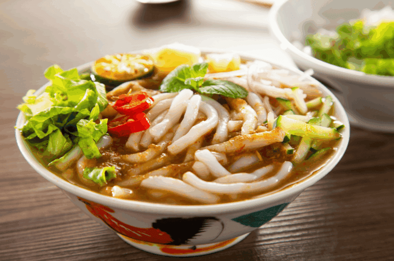 A vibrant bowl of Peranakan-style noodles with vegetables on a rustic wooden table, highlighting Singapore’s rich culinary heritage.
