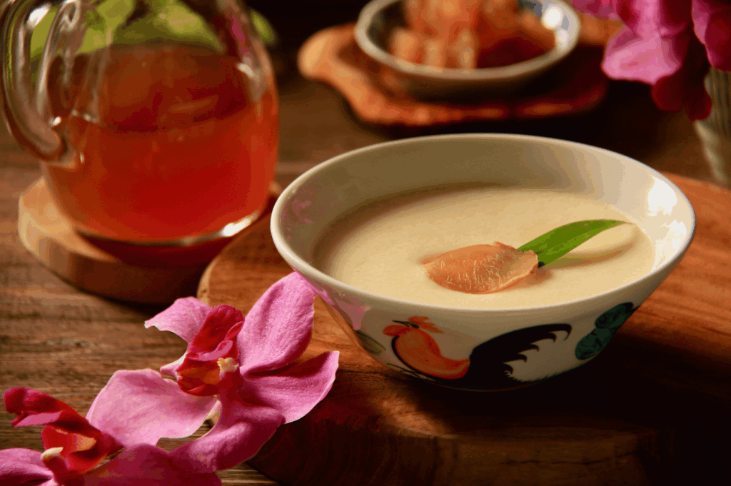 A bowl of Tau Huay on a rustic wooden table, photographed in soft natural light—evoking homestyle sweetness in Singapore’s dessert culture.