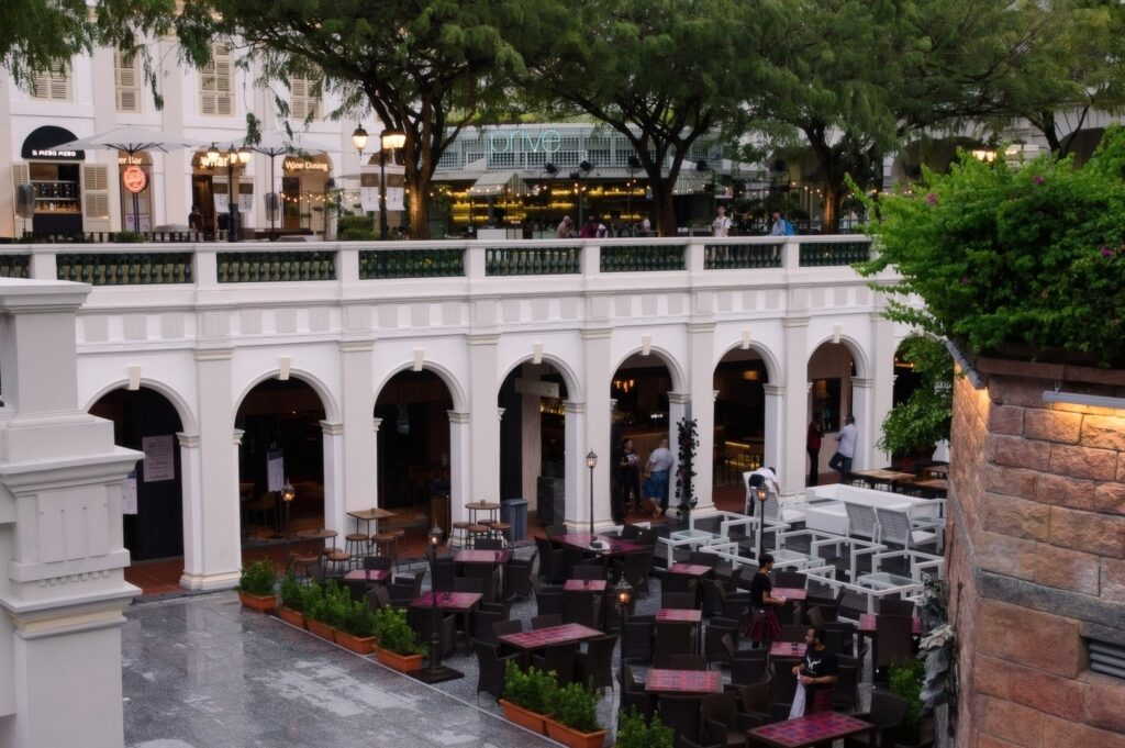 Outdoor seating area in a city courtyard at CHIJMES Bar Singapore, with tables and chairs arranged for guests.