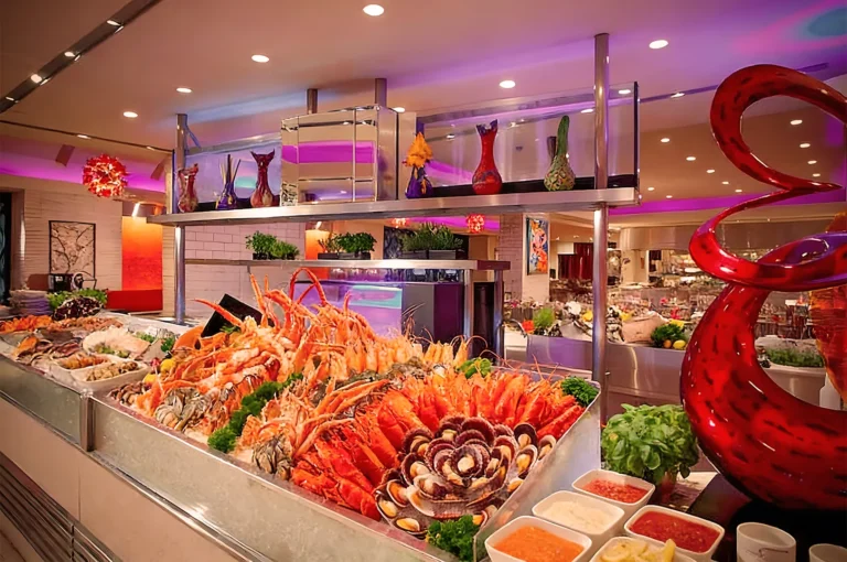 Vibrant seafood buffet featuring lobsters, crabs, prawns, oysters, and mussels on ice, surrounded by colorful décor and modern restaurant lighting.