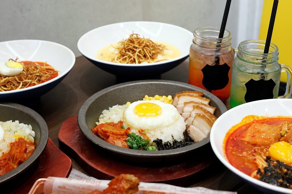 A bustling restaurant in Plaza Singapura, filled with diners enjoying meals and drinks at various tables.