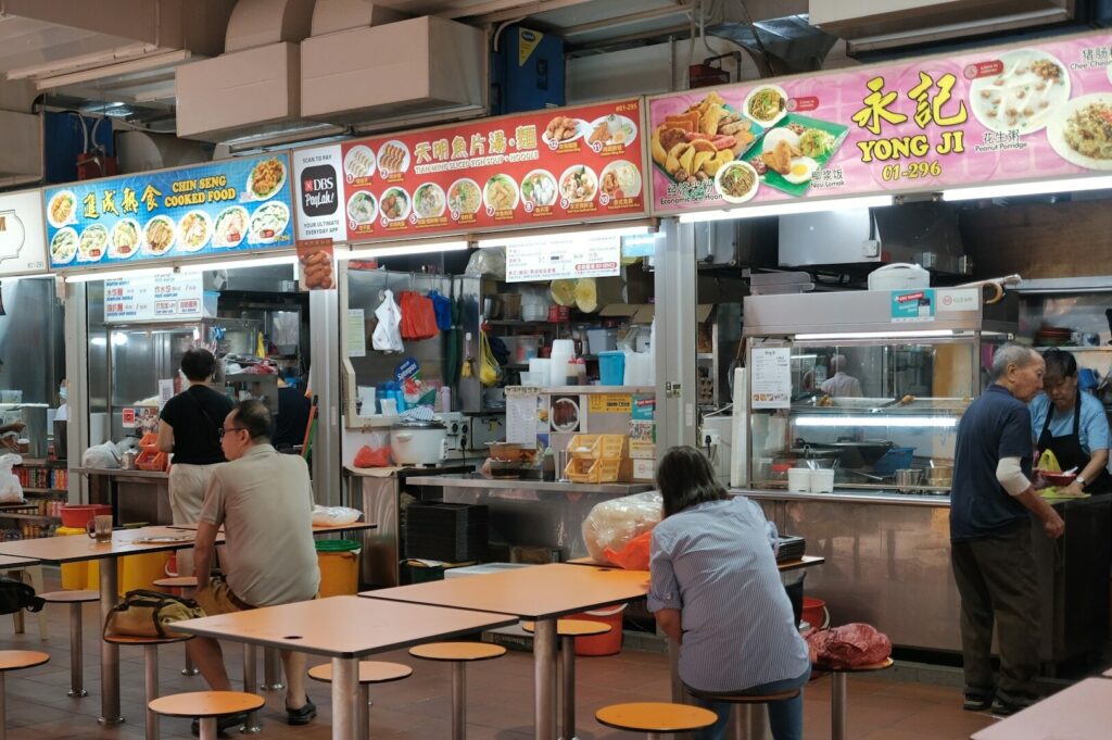 Interior view of Food Plaza Singapore, showcasing a vibrant dining area filled with tables and chairs.