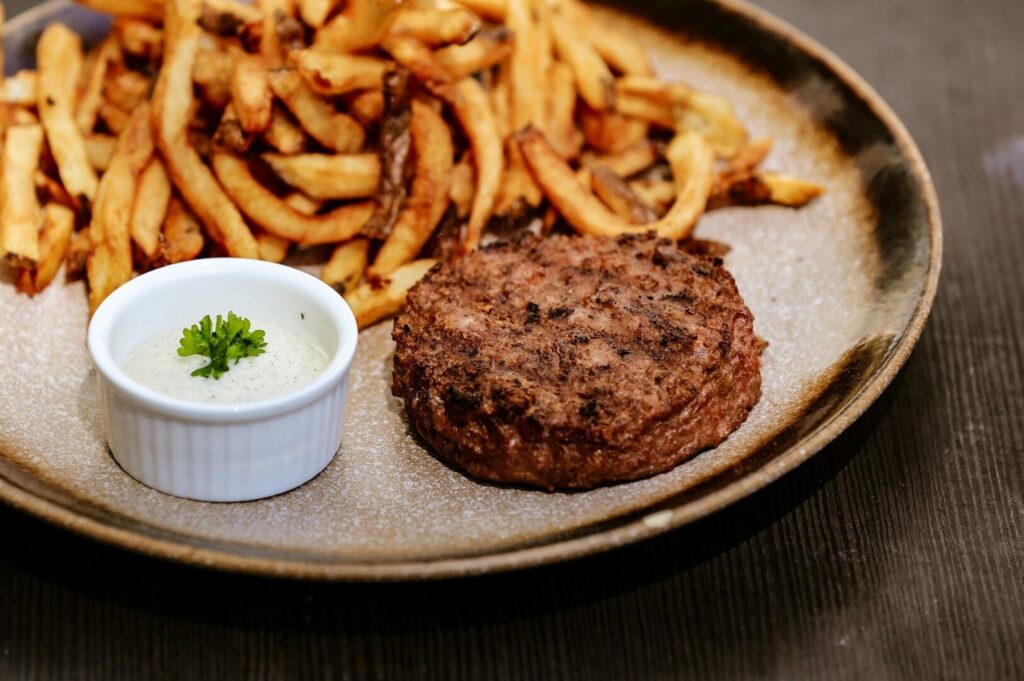 A plate featuring a juicy burger alongside crispy French fries, representing Singapore's diverse food culture.