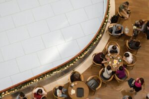 A group of diners seated at tables in a bustling Singapore restaurant, enjoying their meals and conversation.