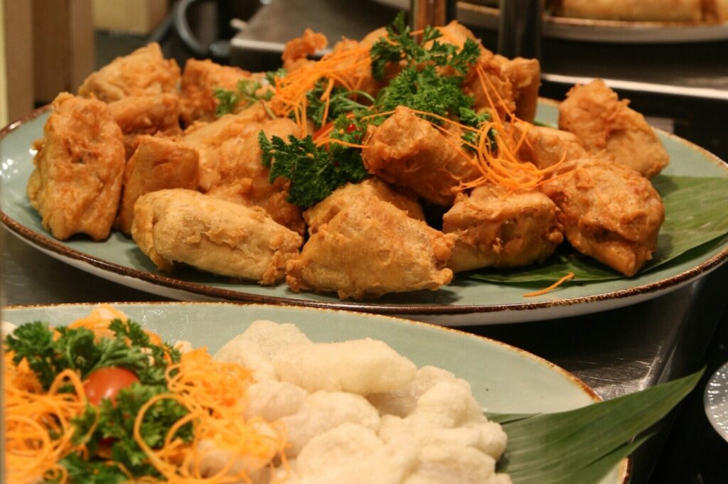 A vibrant buffet spread featuring various dishes on a table, showcasing Singapore dining culture.