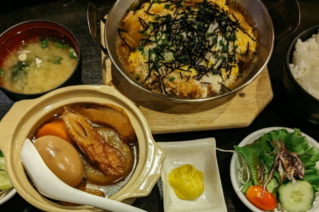 A table set with various bowls of food and soup, showcasing the vibrant flavors of Singapore's food culture.