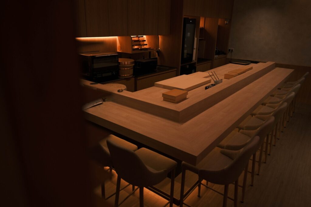 Interior view of a kitchen with a counter and chairs, reflecting the style of Sushi Masa.