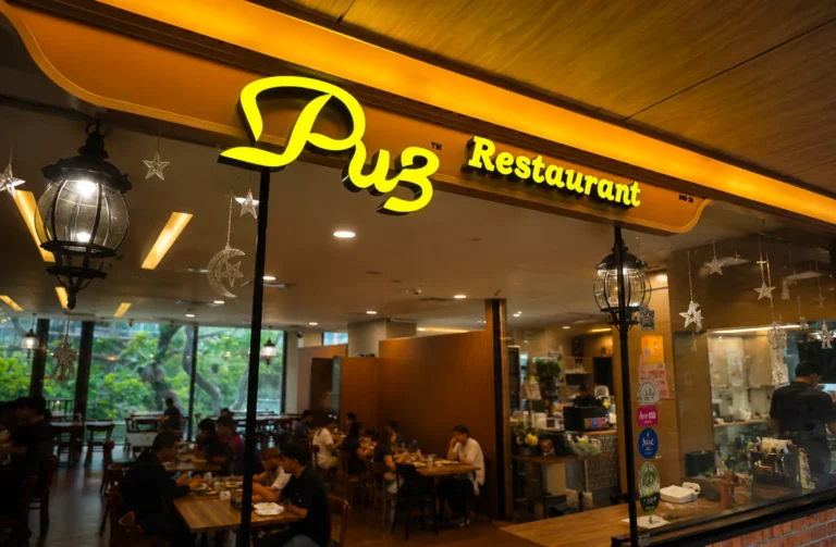 Pu3 Restaurant storefront with bright yellow signage and warm interior lighting
