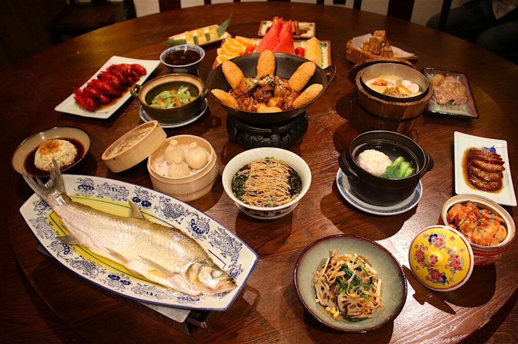 A table filled with various seafood and other dishes at Plaza Singapura, showcasing a vibrant culinary spread.