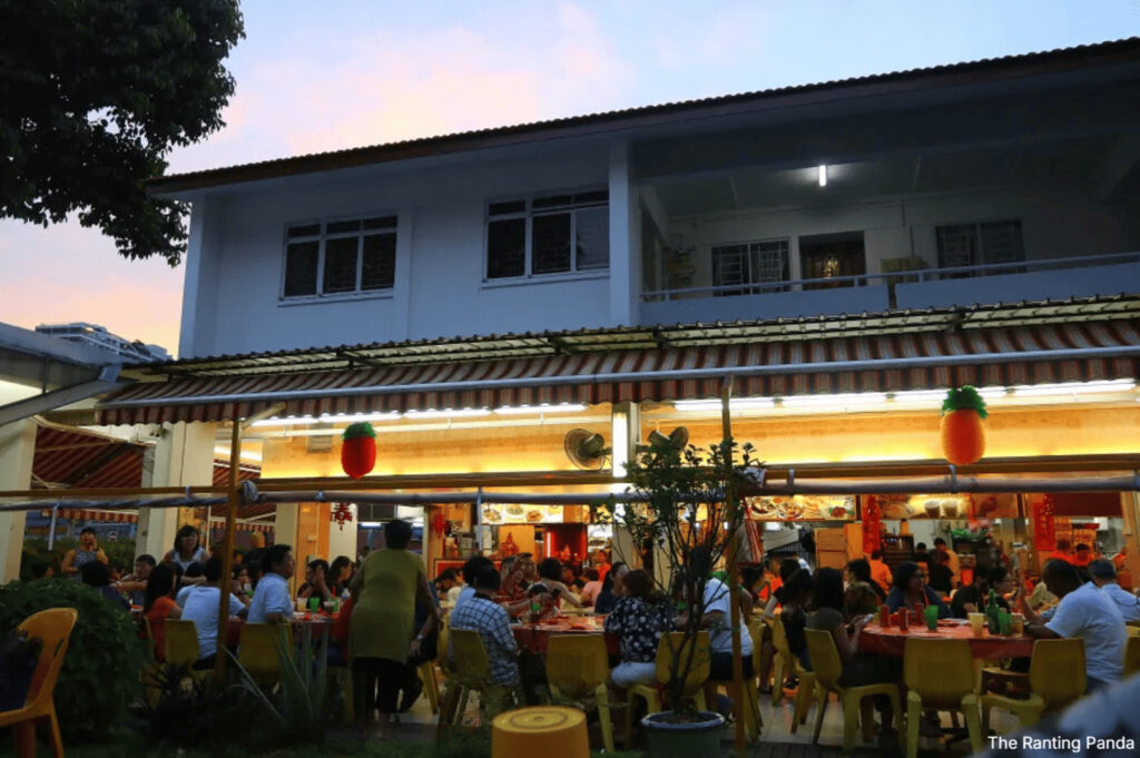 Keng Eng Kee Seafood restaurant filled with diners seated at tables outside, creating a lively atmosphere.