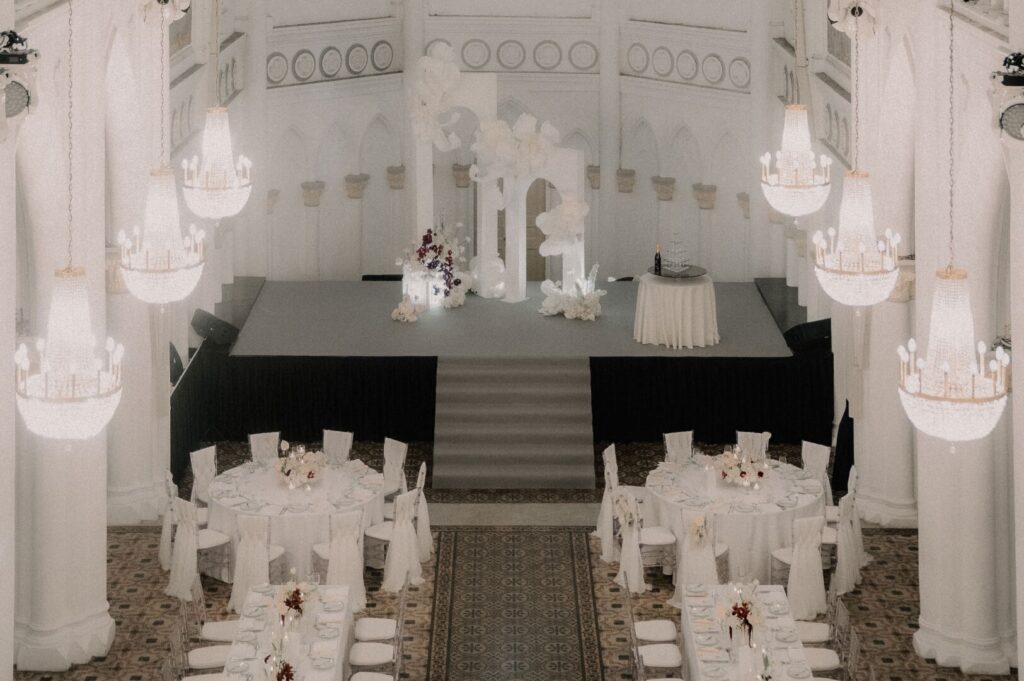 Overhead view of a wedding reception in CHIJMES Hall, Singapore, showcasing elegant decor and guests enjoying the celebration.