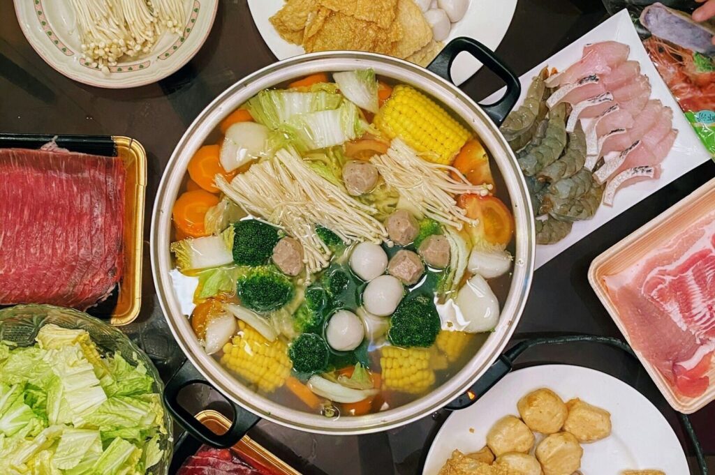 A table filled with various plates of food and meat, showcasing the vibrant Singapore food scene.
