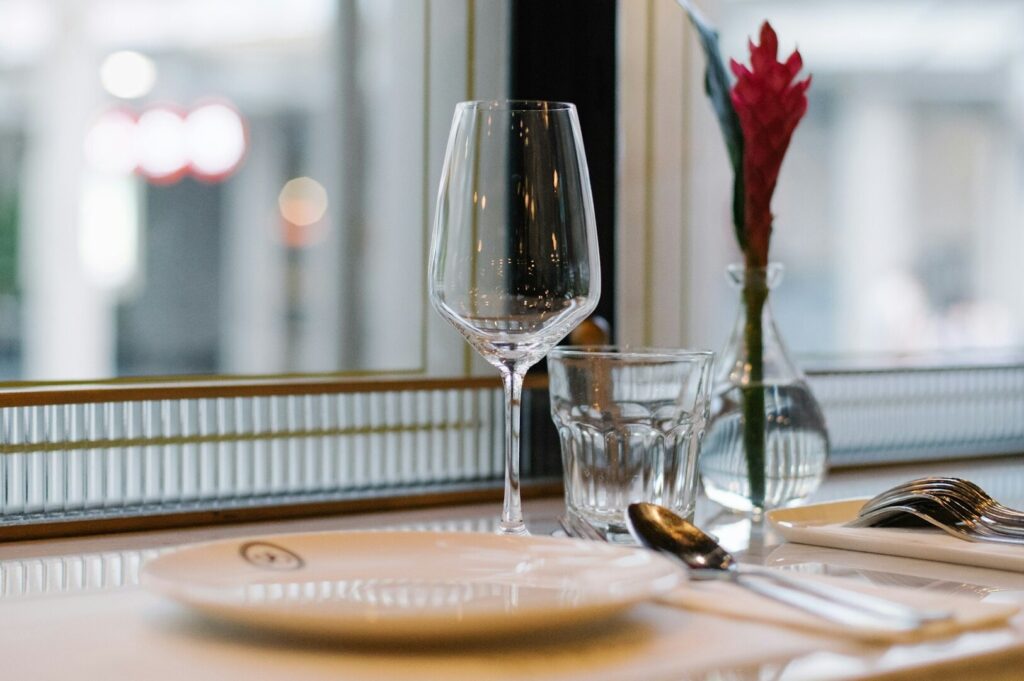 A table in Singapore displaying a glass, a plate, and silverware, ready for a meal.