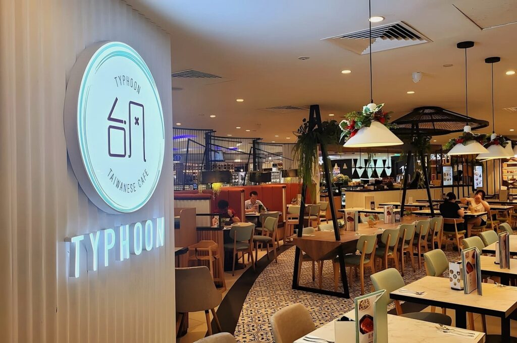 Interior view of Typhoon Cafe at Plaza Singapura, featuring tables and chairs arranged for dining.