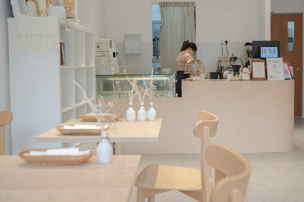A woman is positioned in front of a counter, highlighting the inviting ambiance of a Singapore cafe.