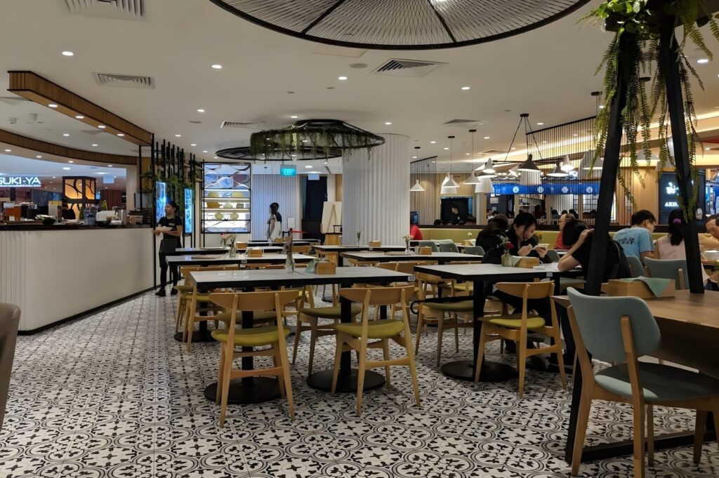 A view of Food Plaza Singapore featuring tables and chairs arranged in the center of the restaurant.