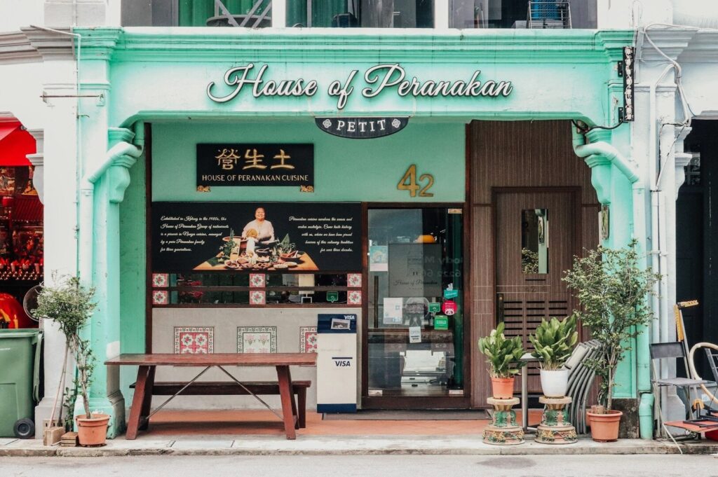 A restaurant exterior featuring a sign that reads "House of Peranakan," highlighting Singapore's vibrant food culture.