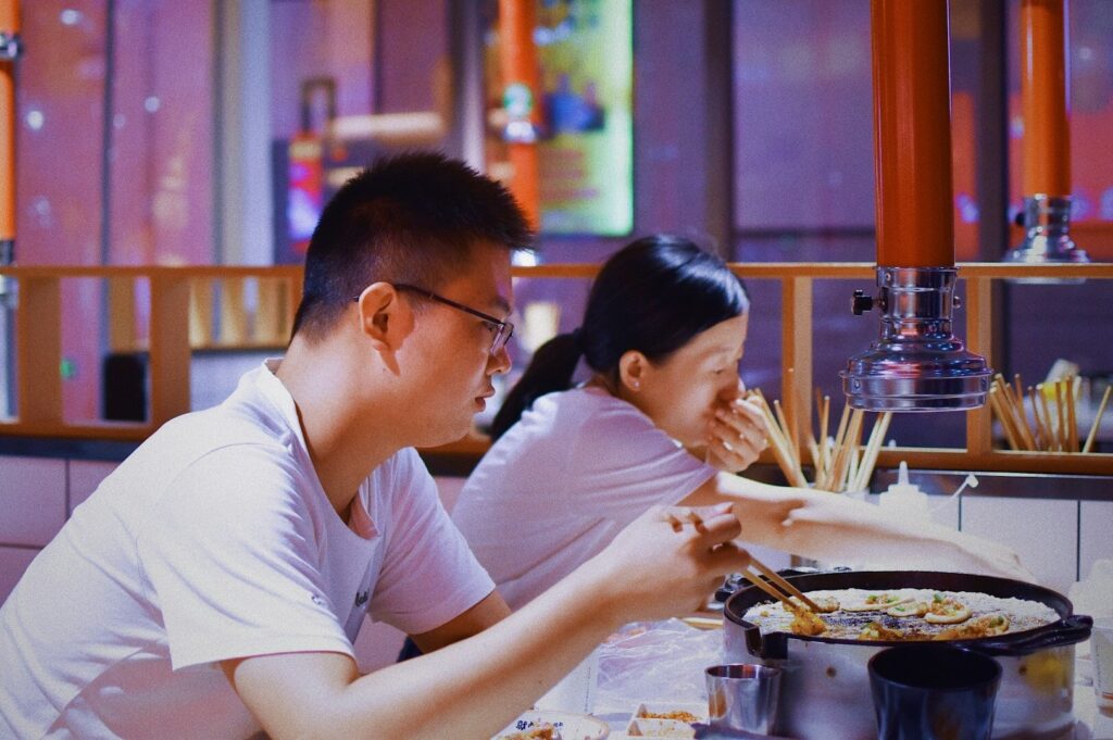 A man and woman enjoying a meal together at a restaurant, showcasing Singapore's vibrant dining culture.