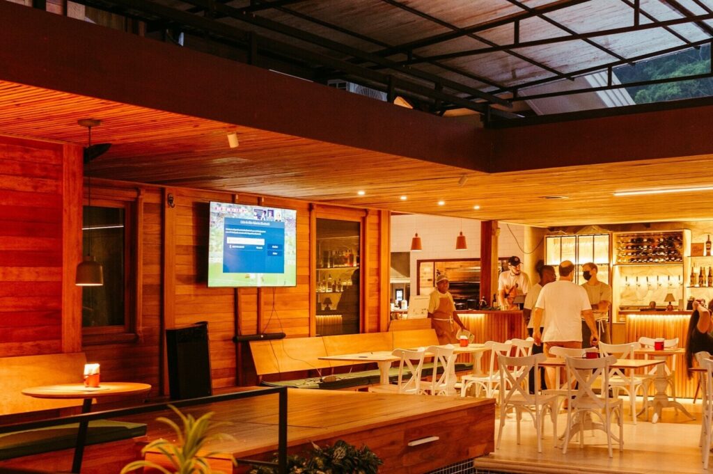 Interior of a Singapore restaurant featuring patrons at tables and a television.