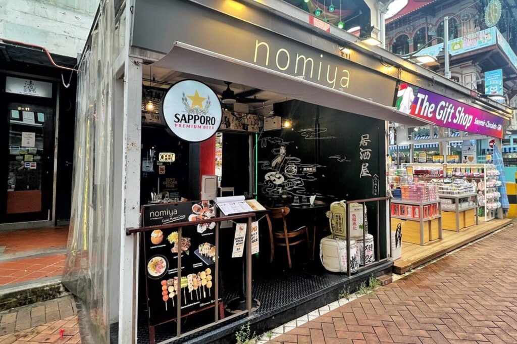 Exterior view of a cozy restaurant named "Nomiya," showcasing its identity as a Singapore Izakaya.