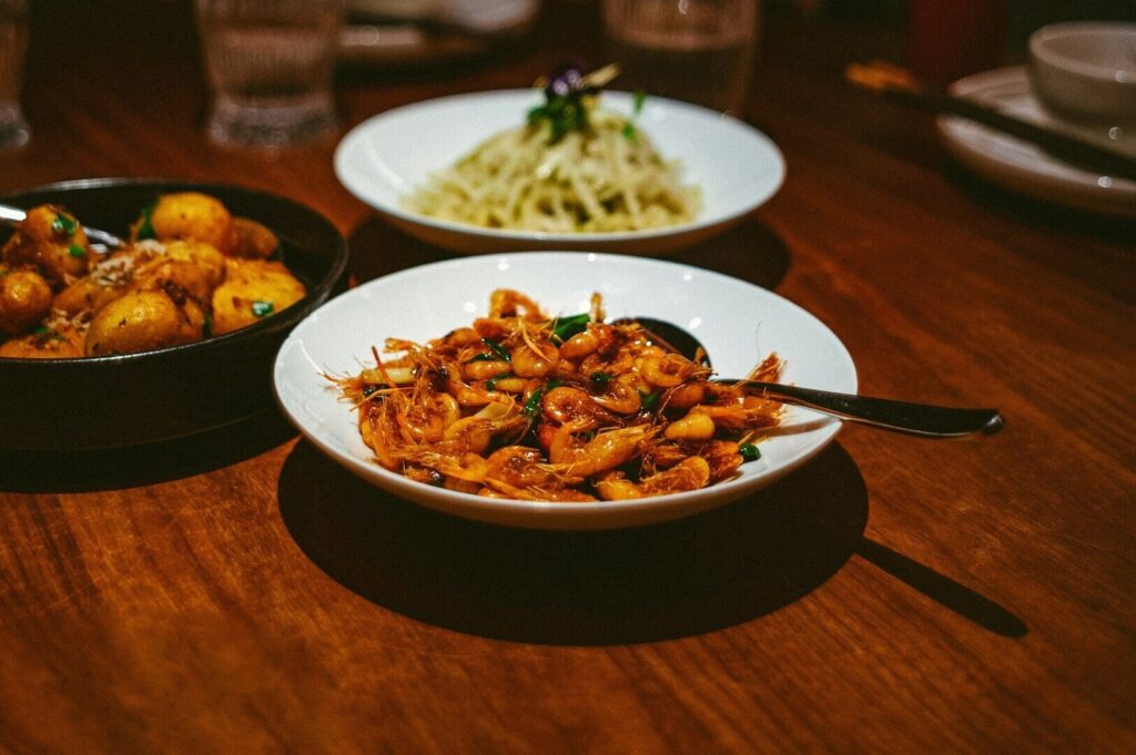 A table set with various bowls of food and a spoon, showcasing premier dining in Singapore.
