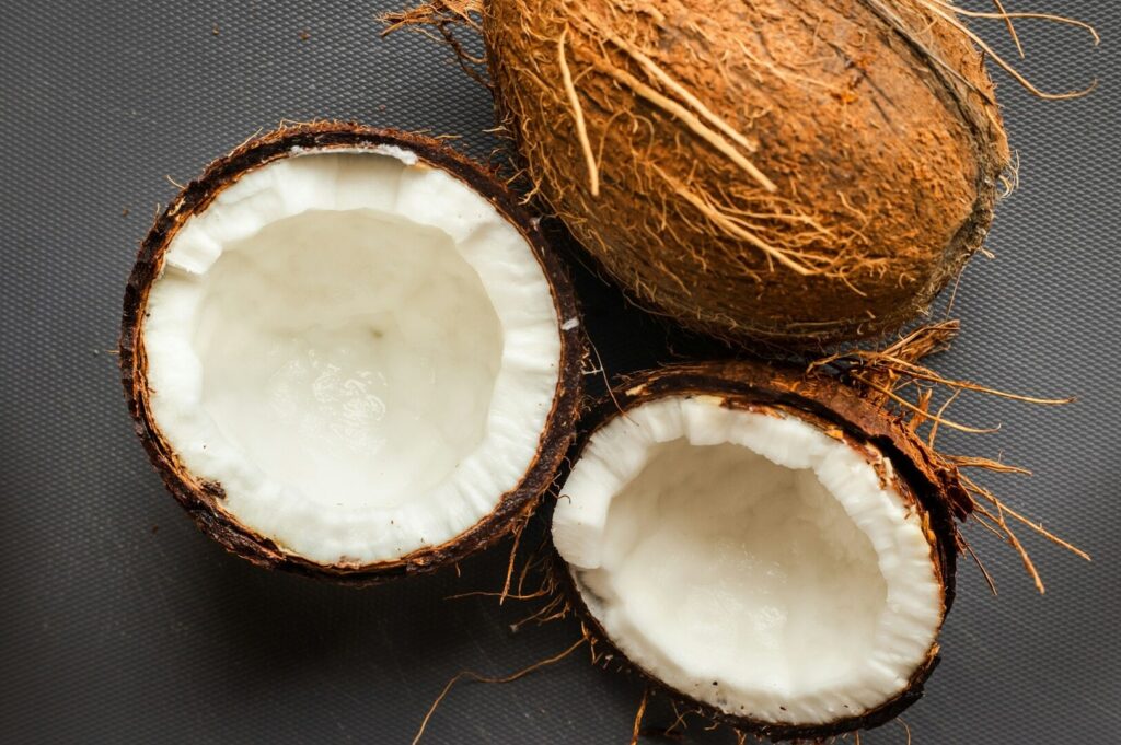 A close-up image shows a fresh coconut, highlighting the use of quality plant-based ingredients in vegetarian cuisine. This process reflects the authentic flavors of Peranakan culture, emphasizing the importance of fresh ingredients in creating delicious, meat-free dishes.