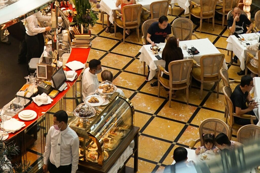 A bustling restaurant in Singapore with diners enjoying meals and drinks at tables, creating a lively atmosphere.