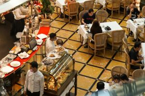 A bustling restaurant in Singapore with diners enjoying meals and drinks at tables, creating a lively atmosphere.