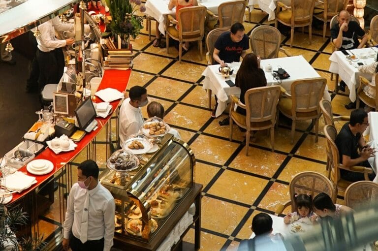 A bustling restaurant in Singapore with diners enjoying meals and drinks at tables, creating a lively atmosphere.