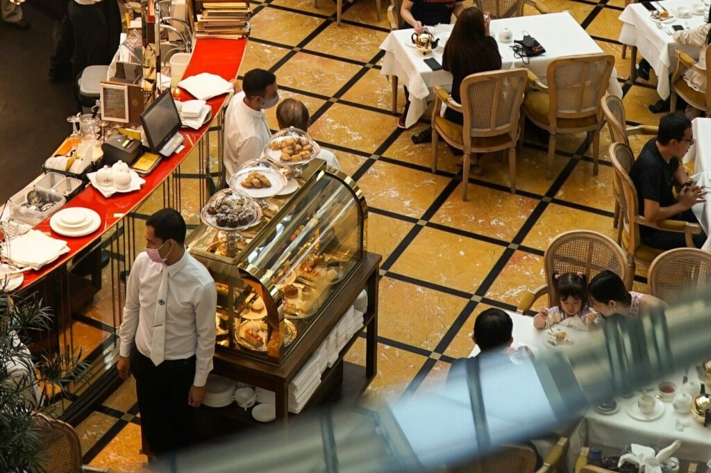 Interior view of a lively restaurant in Singapore, featuring patrons eating and socializing.