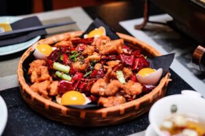 A plate served with raw eggyolks and various ingredients, showcasing a selection of food from Plaza Singapura.
