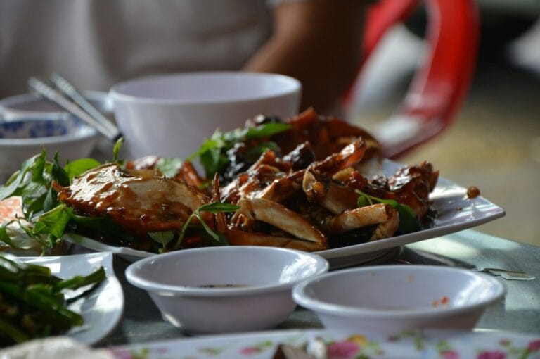 A vibrant table filled with various Singaporean hawker dishes, showcasing colorful plates of food and diverse culinary delights.