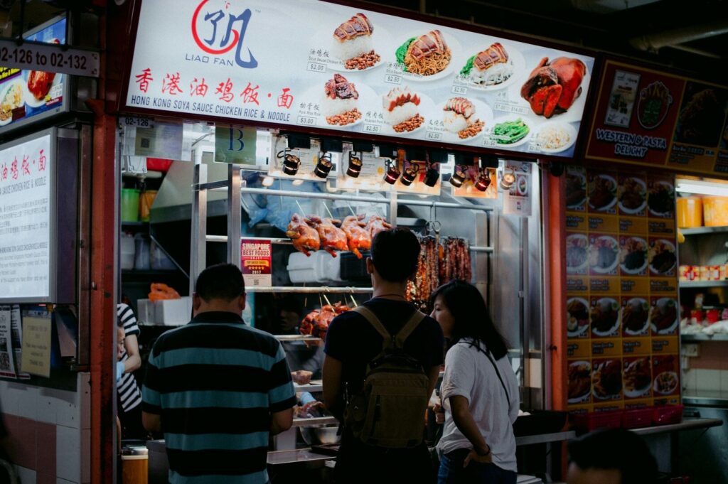 A person presents a tray featuring two bowls of food, highlighting the rich diversity of Singapore's culinary culture.