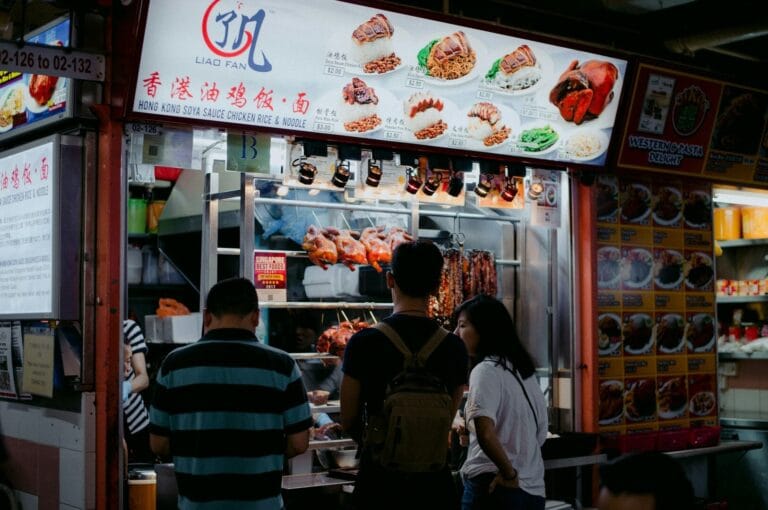 A person presents a tray featuring two bowls of food, highlighting the rich diversity of Singapore's culinary culture.