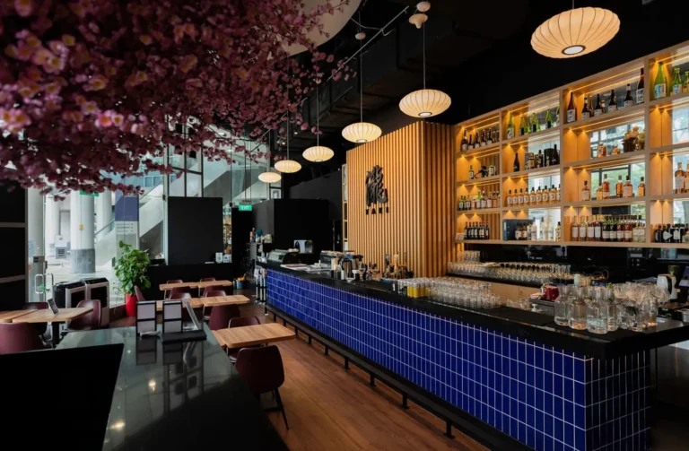 Interior of Singapore Izakaya bar with blue tiled walls and a flower suspended from the ceiling.
