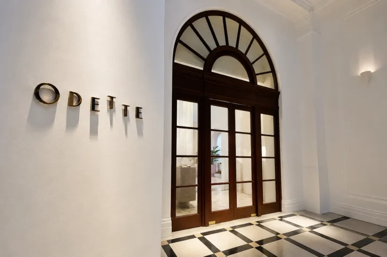 Odette restaurant entrance with gold signage and arched wooden doors