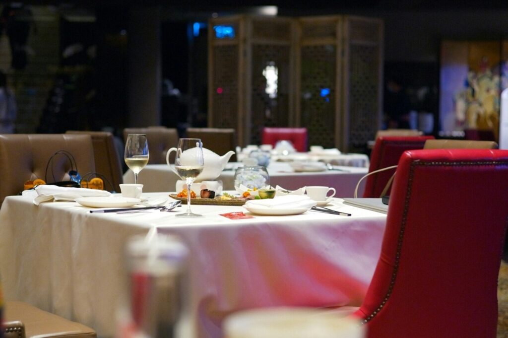 A neatly set table with a white tablecloth, located in a restaurant in Singapore.