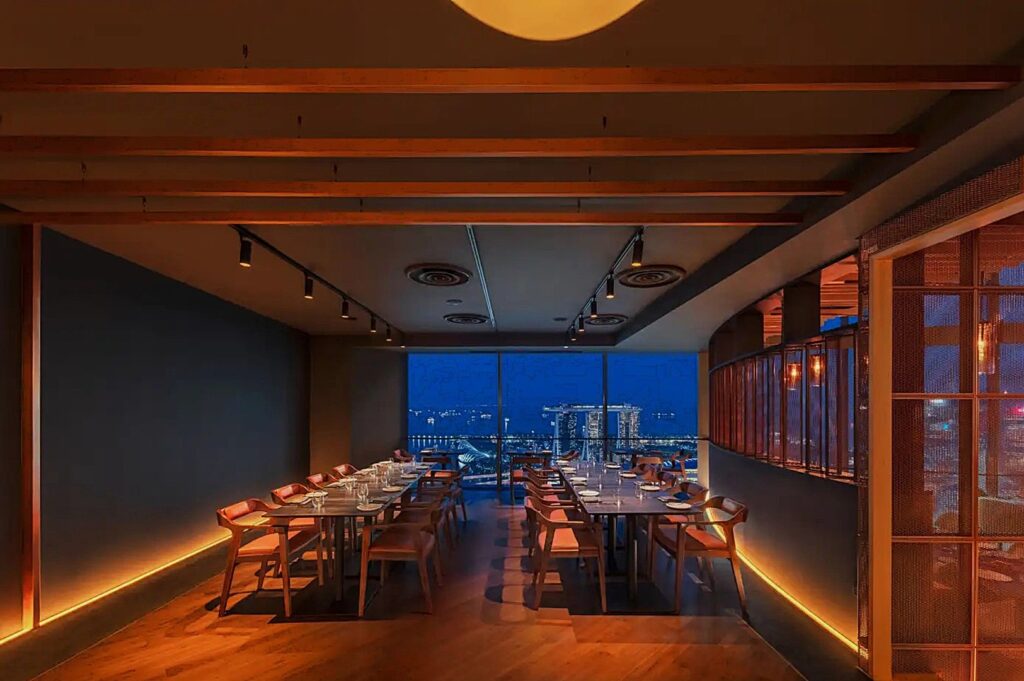 Rooftop view from SKAI bar at Japan Hotel, showcasing Singapore's iconic Marina Bay Sands and vibrant cityscape in the background.