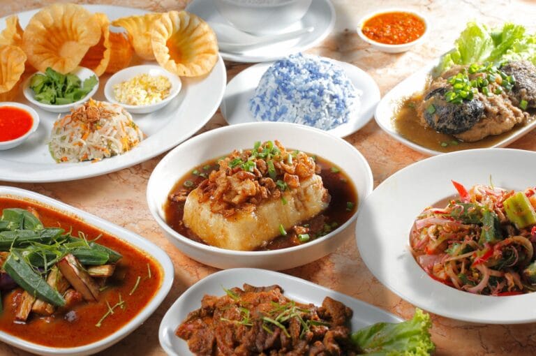 A vibrant display of Peranakan dishes arranged on a table, highlighting the diversity of flavors and ingredients.