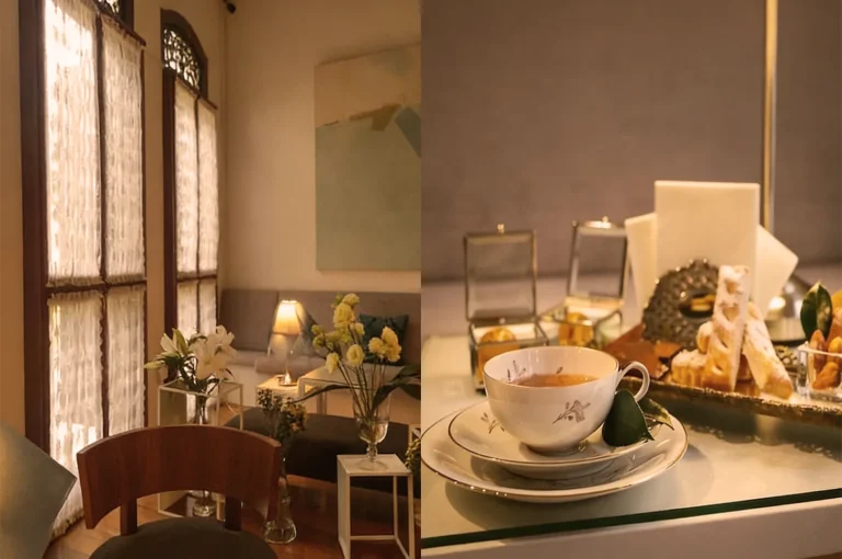 Cozy cafe with soft lighting, elegant decor, and a wooden chair near a window. A tea set and pastries are arranged on a chic table.