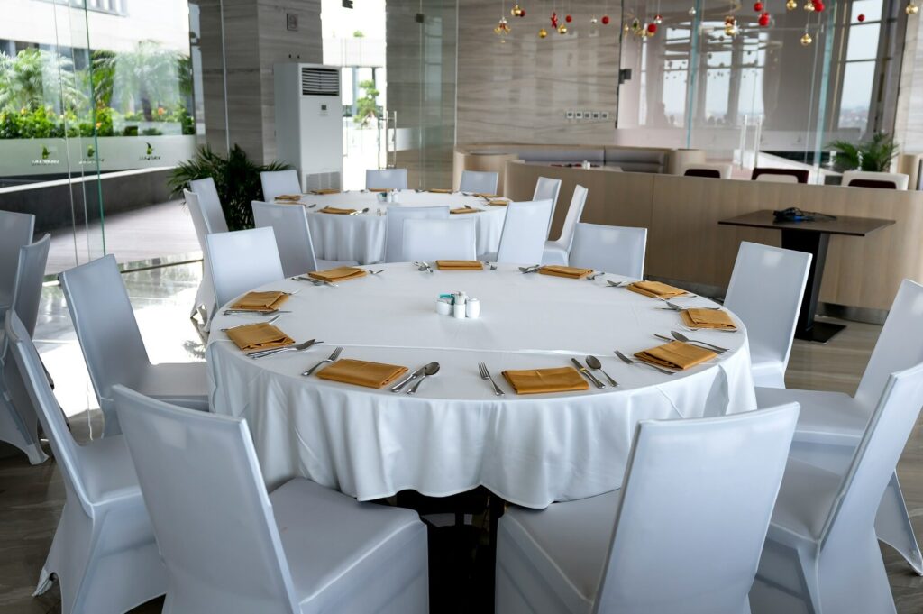 A round dining table draped with white cloths, showcasing a Singapore dining setting.