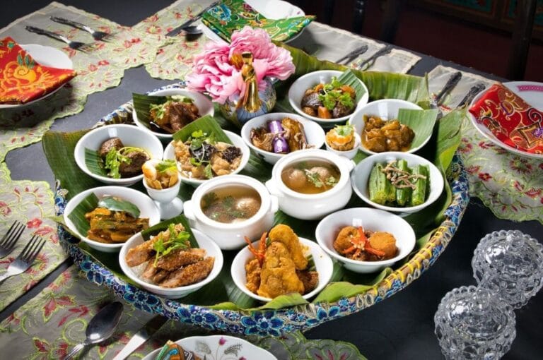 A large platter of colorful Peranakan food displayed on a table, showcasing various traditional dishes and vibrant ingredients.