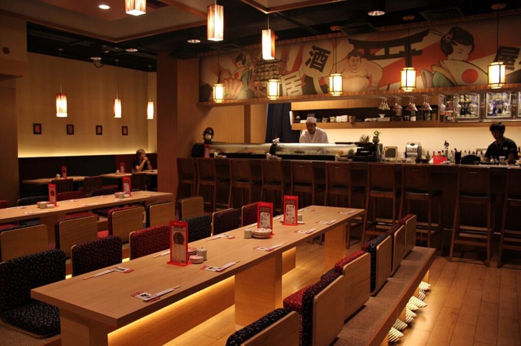 A cozy restaurant interior featuring wooden tables and chairs, named Singapore Izakaya.