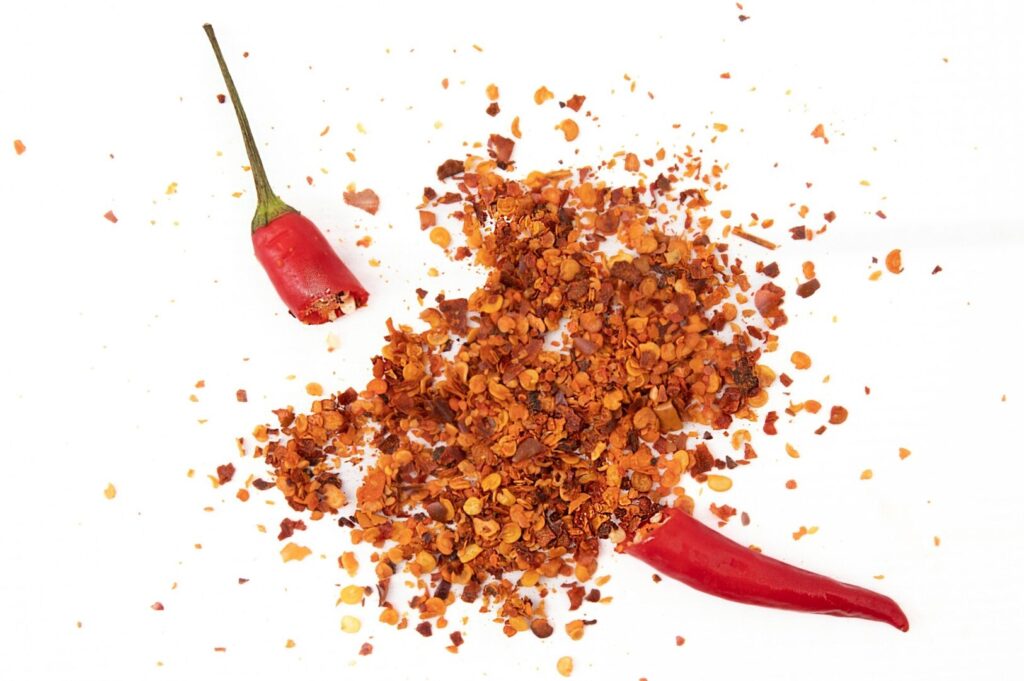 A vibrant chili pepper, set against a clean white background, representing Peranakan spice culture.