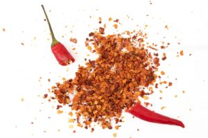 A vibrant chili pepper, set against a clean white background, representing Peranakan spice culture.