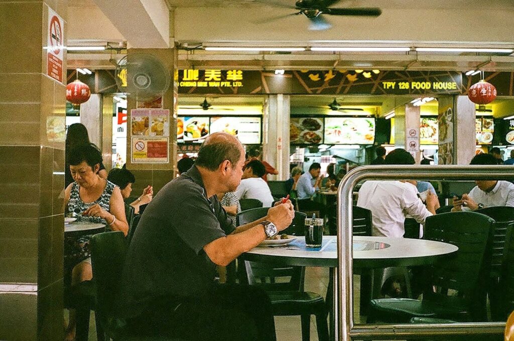 A man seated at a table, savoring a meal in an upscale dining setting in Singapore.