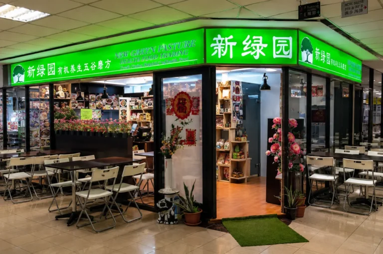 New Green Pasture health food shop with green signage and dining tables
