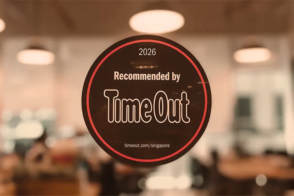 2026 Time Out Singapore recommended sticker on restaurant window, black background with red border, highlighting venue endorsement and credibility.