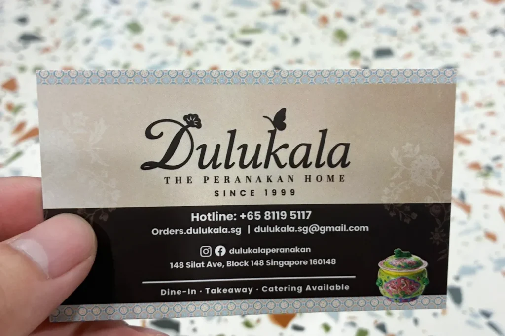 Dulukala The Peranakan Home business card showing contact details, address at Silat Ave, and website information.